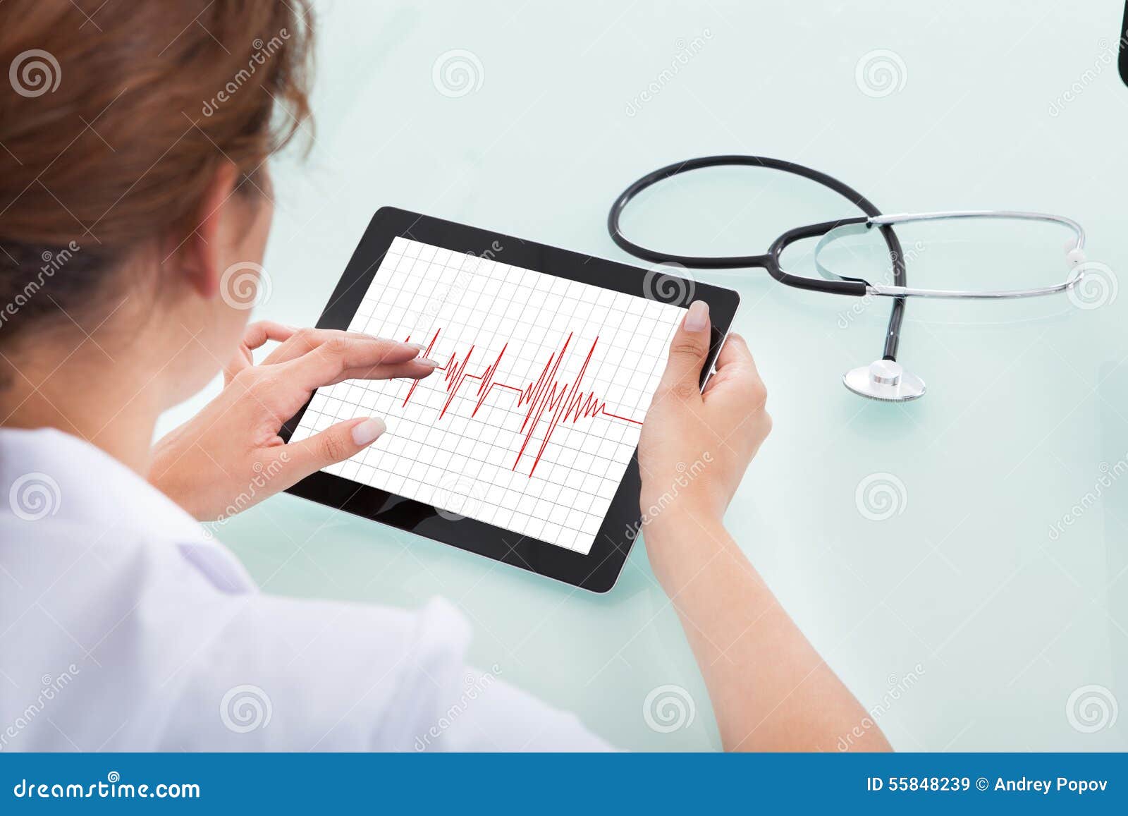cardiologist analyzing heartbeat on digital tablet