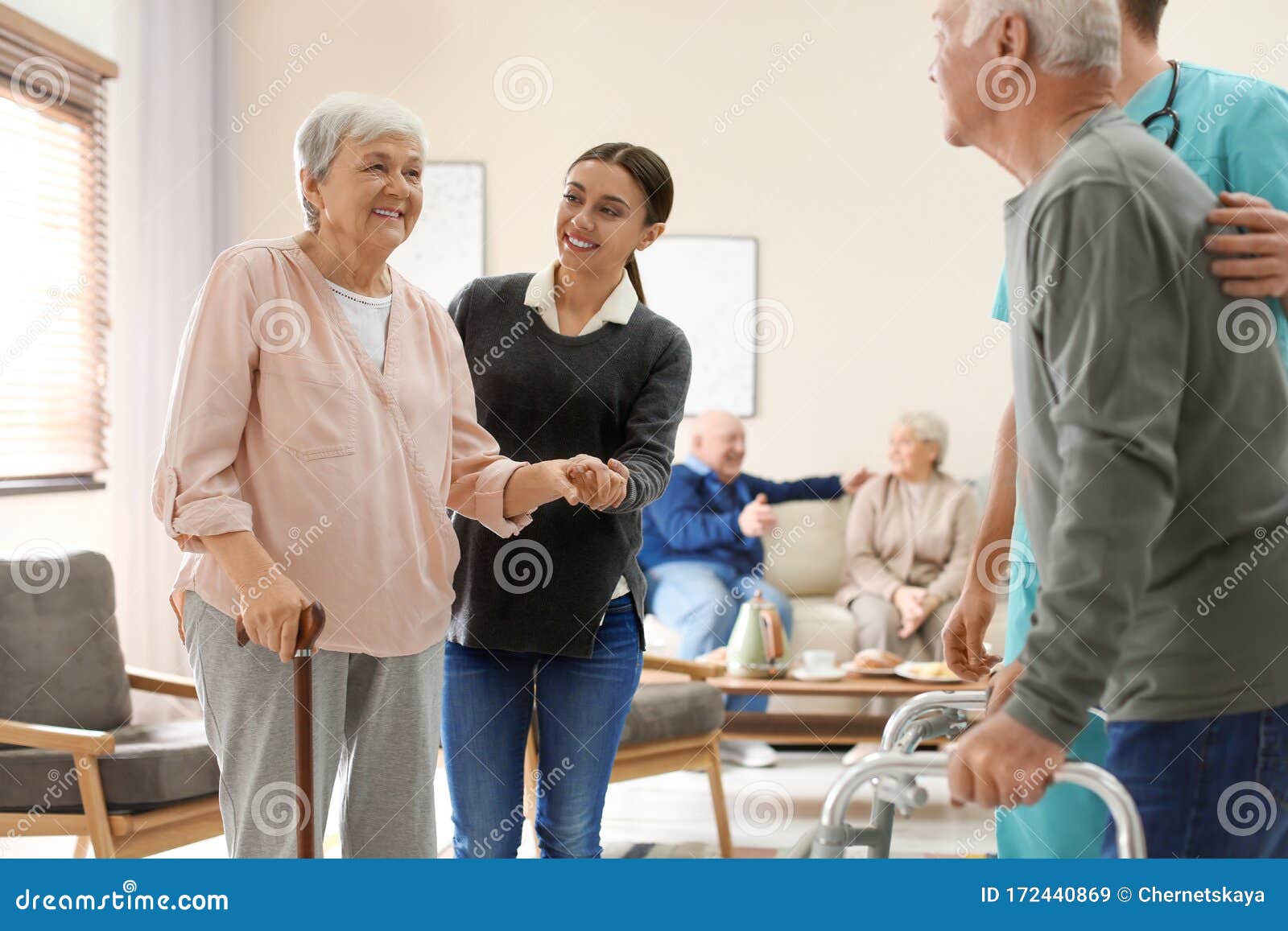 care workers helping to elderly patients to walk in hospice