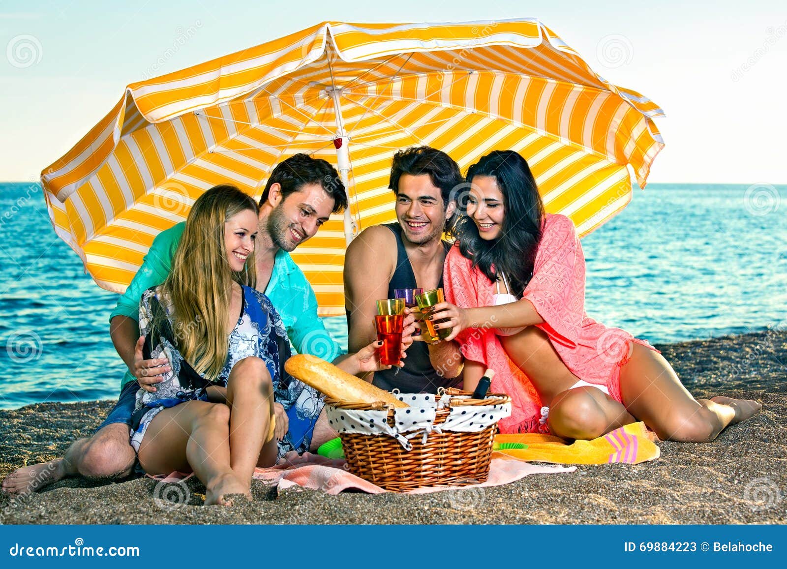 Download Carefree Friends Under Yellow Umbrella With Drinks. Stock ...