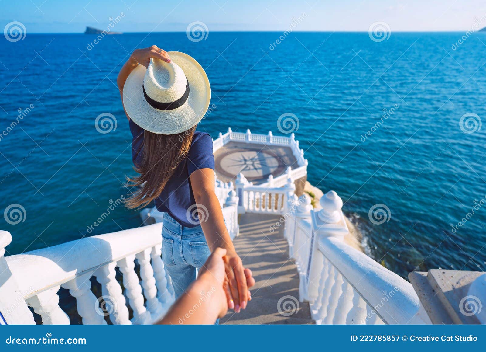 carefree tourist woman in hat leading her boyfriend to the sea view. follow me. balcon del mediterraneo, benidorm, spain