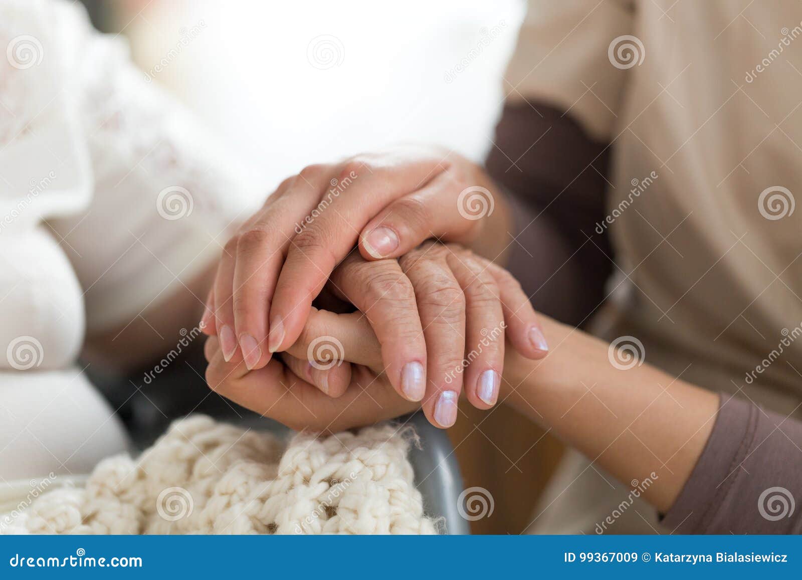 caregiver holding senior woman`s hands