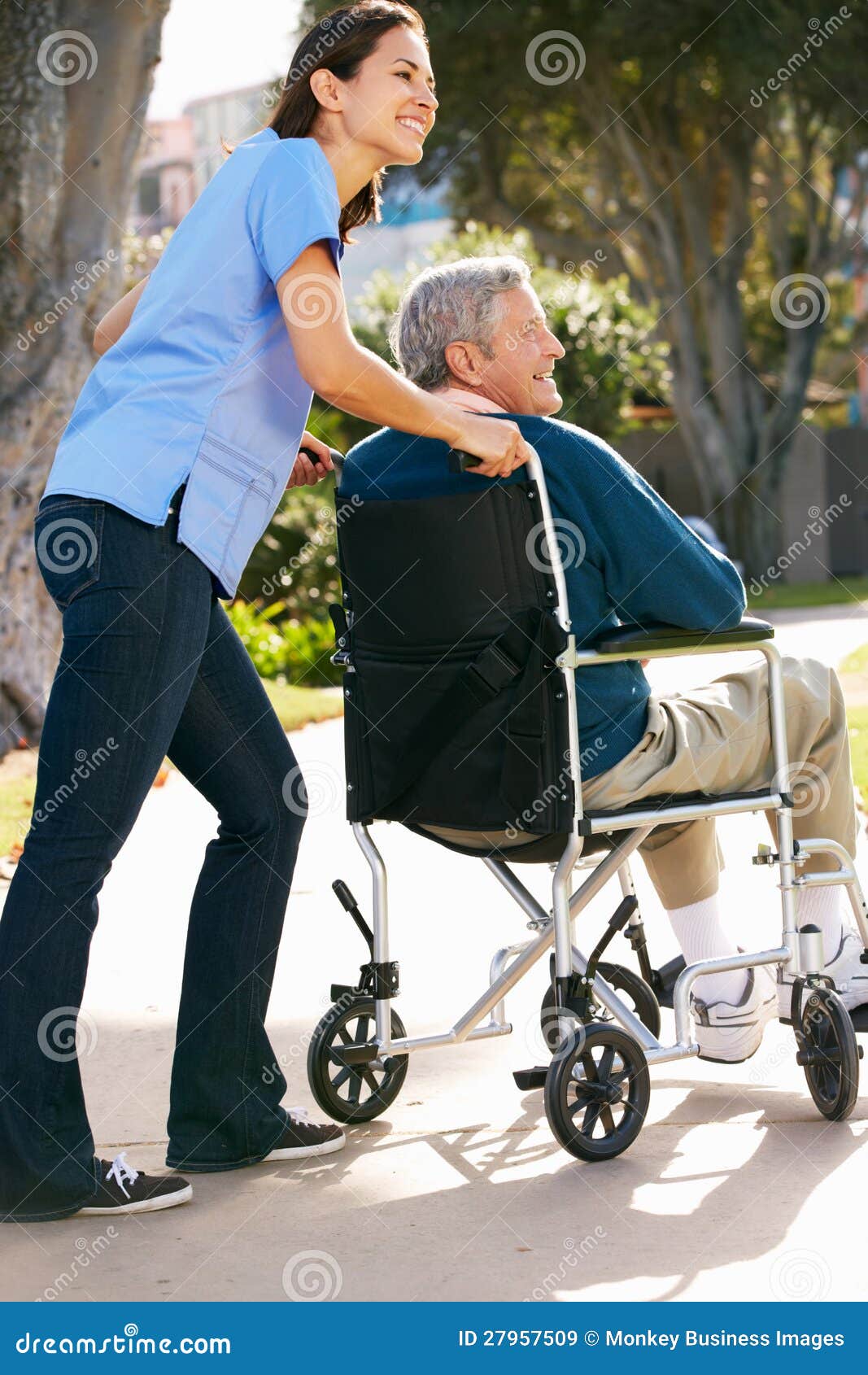 Carer Pushing Senior Man In Wheelchair Royalty Free Stock Images