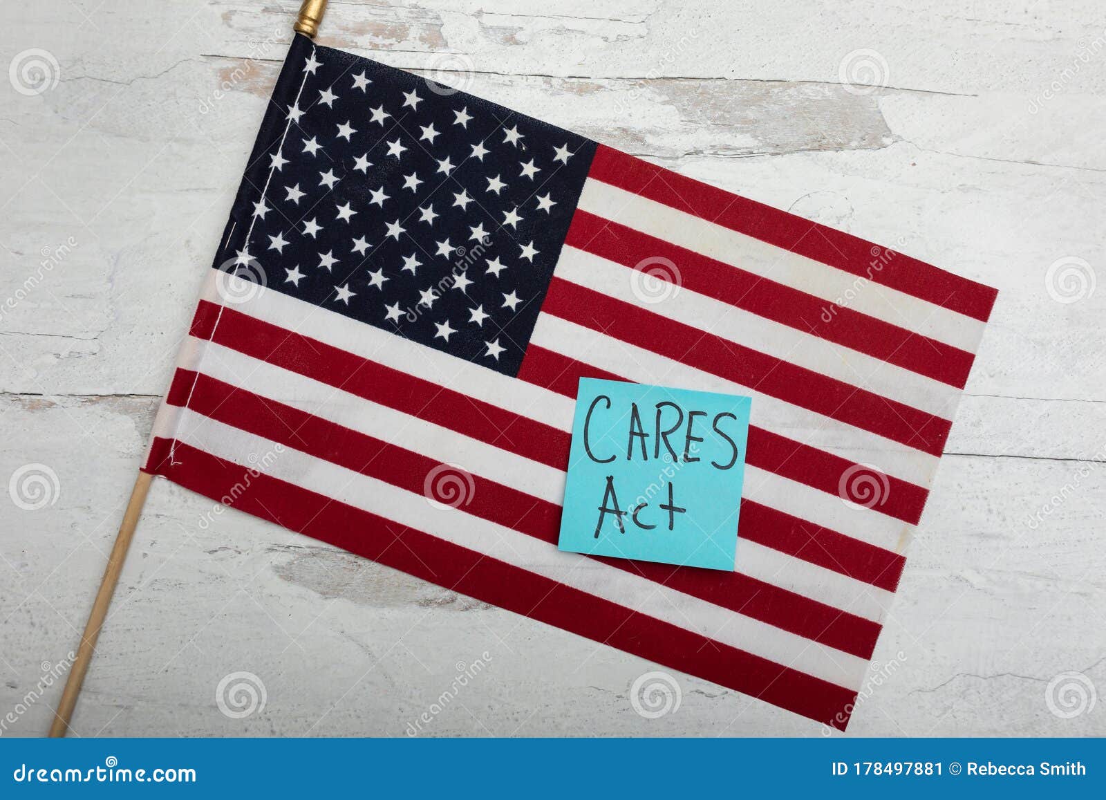 cares act on blue posted note sitting on large american flag