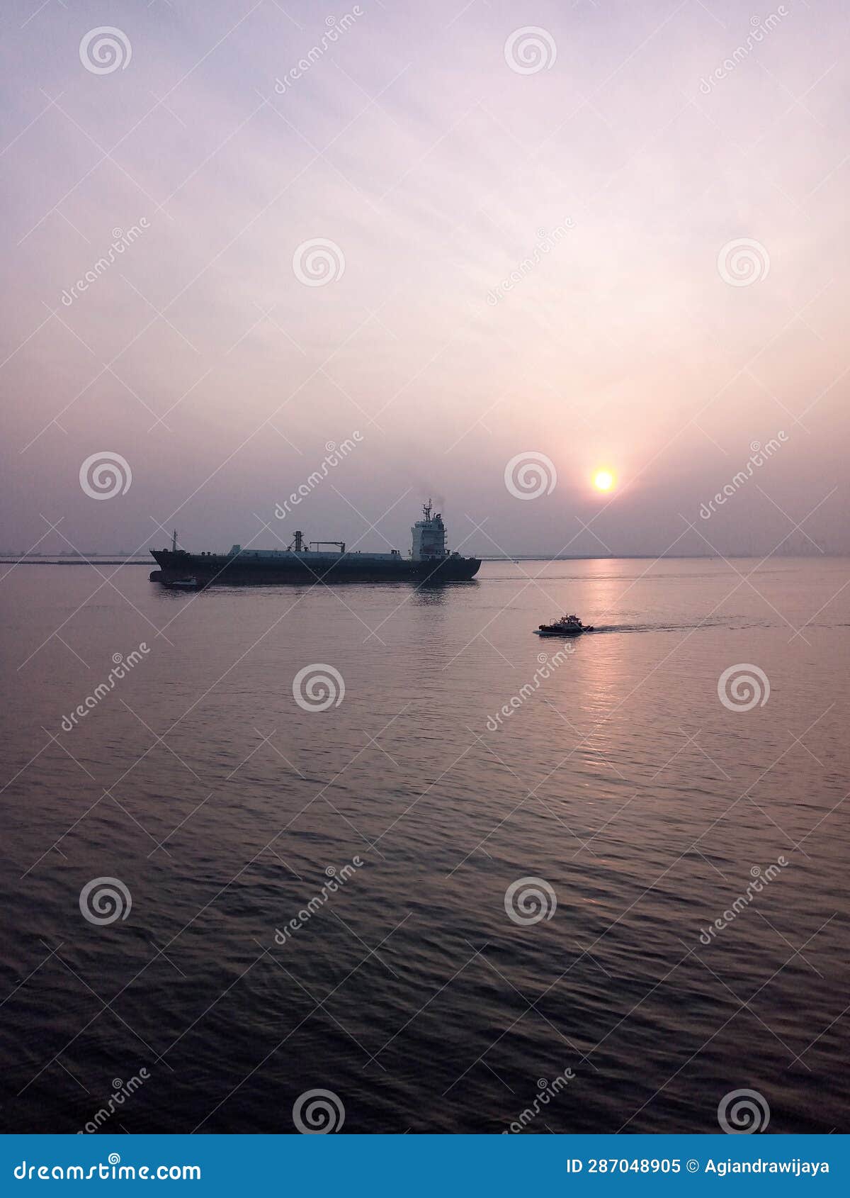 the cargo ship is greeted by the rising sun