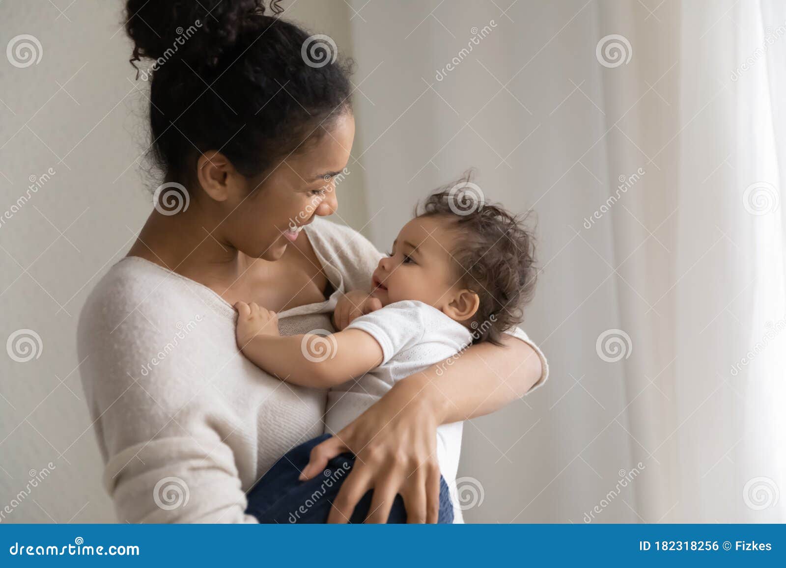 caring african american mom lull small baby