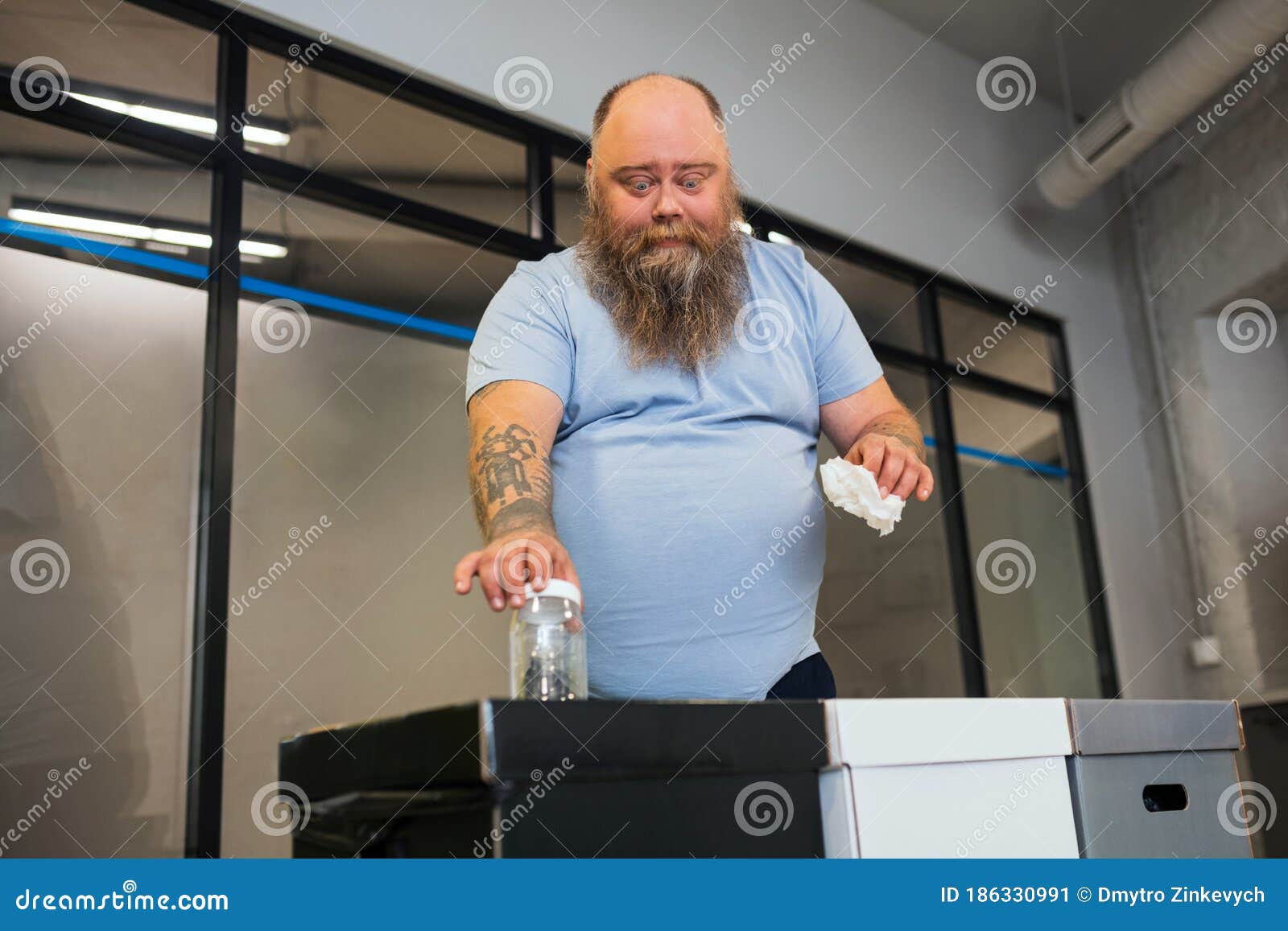 Man with a Big Belly Throwing Trash into Special Boxes Stock Image