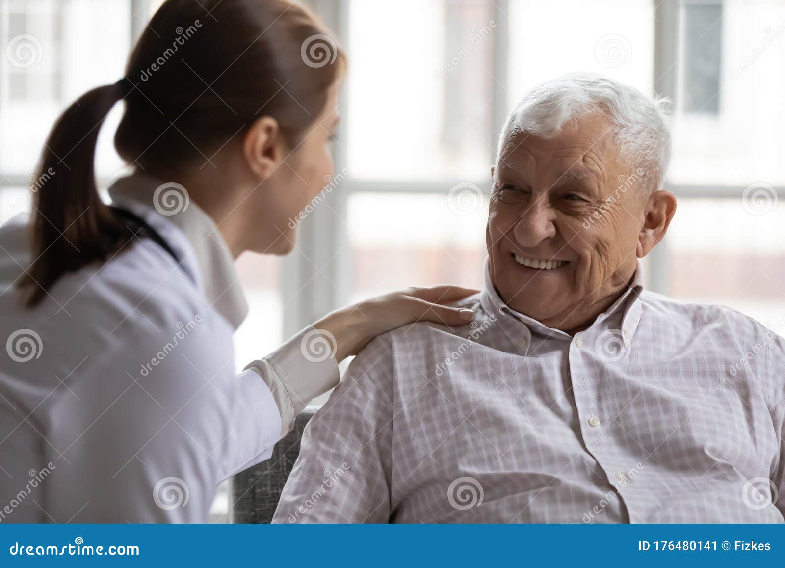 caring geriatric nurse in white coat cares for elderly man