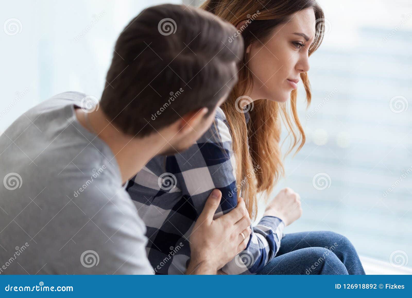 caring man comforting upset wife after fight