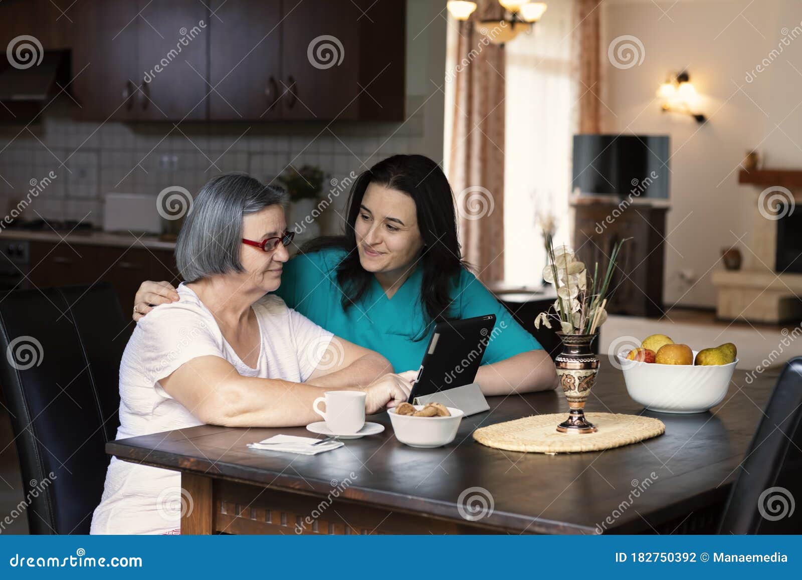 Caring Nurse Showing a Digital Tablet To an Elderly Woman in a Nursing ...
