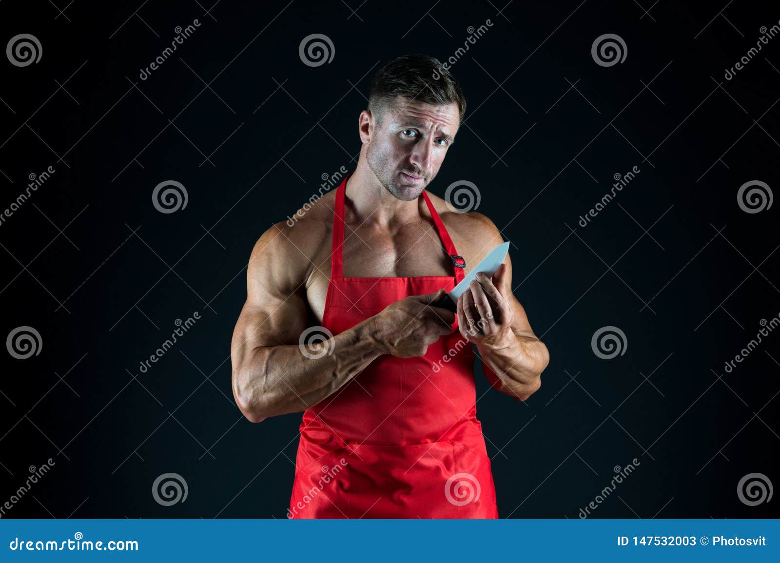 Carnicero Con El Cuchillo Hombre Con El Torso Muscular En Delantal Del Cocinero Cocina Ama De Casa De Sexo Masculino Marido En Co Imagen de archivo