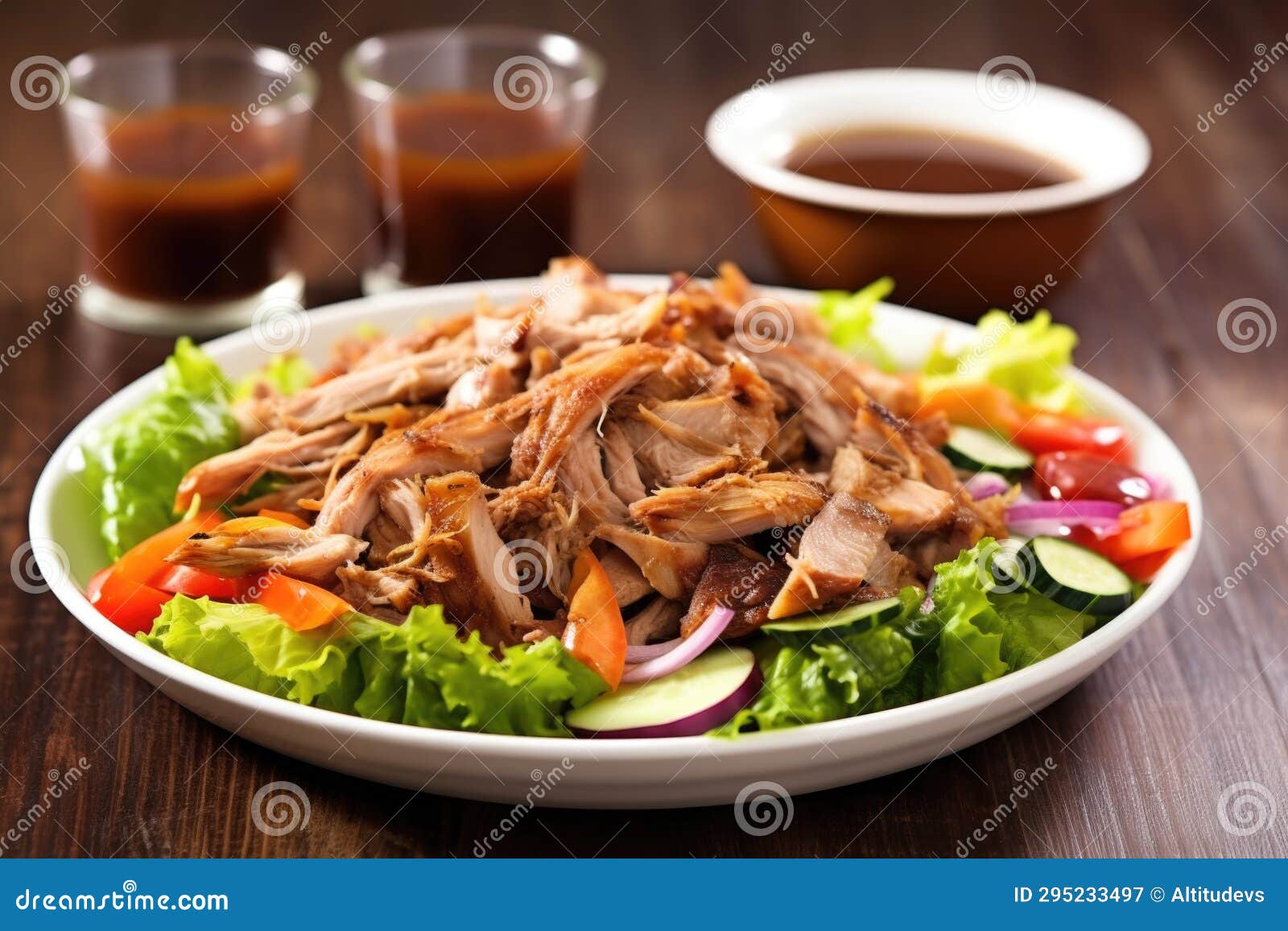 Carolina Pulled Pork Dripping with Vinegar Sauce Placed Over a Salad