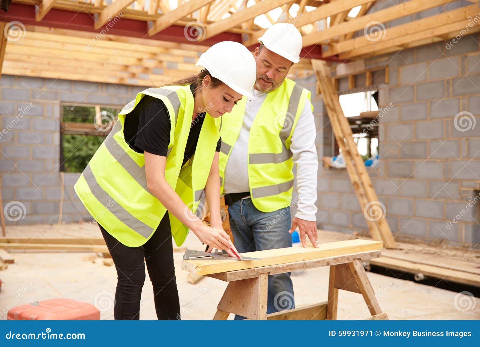 Carpenter with Female Apprentice Working on Building Site Stock Image