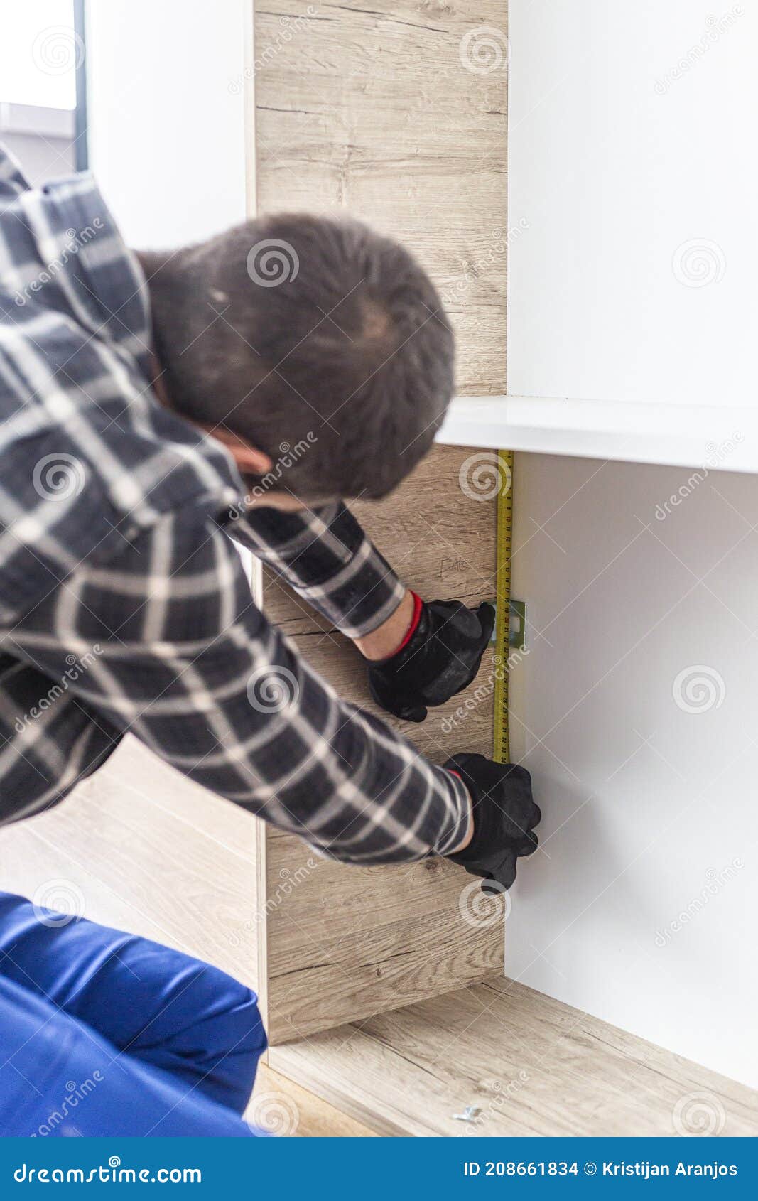 Carpenter Measuring Shelves that are Parts of New Kitchen with Meter