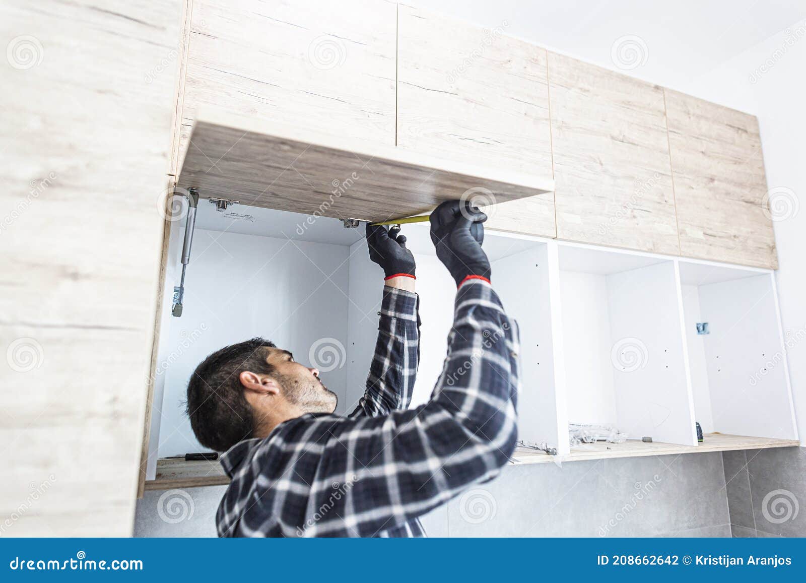 Carpenter Measuring Shelves that are Parts of New Kitchen with Meter