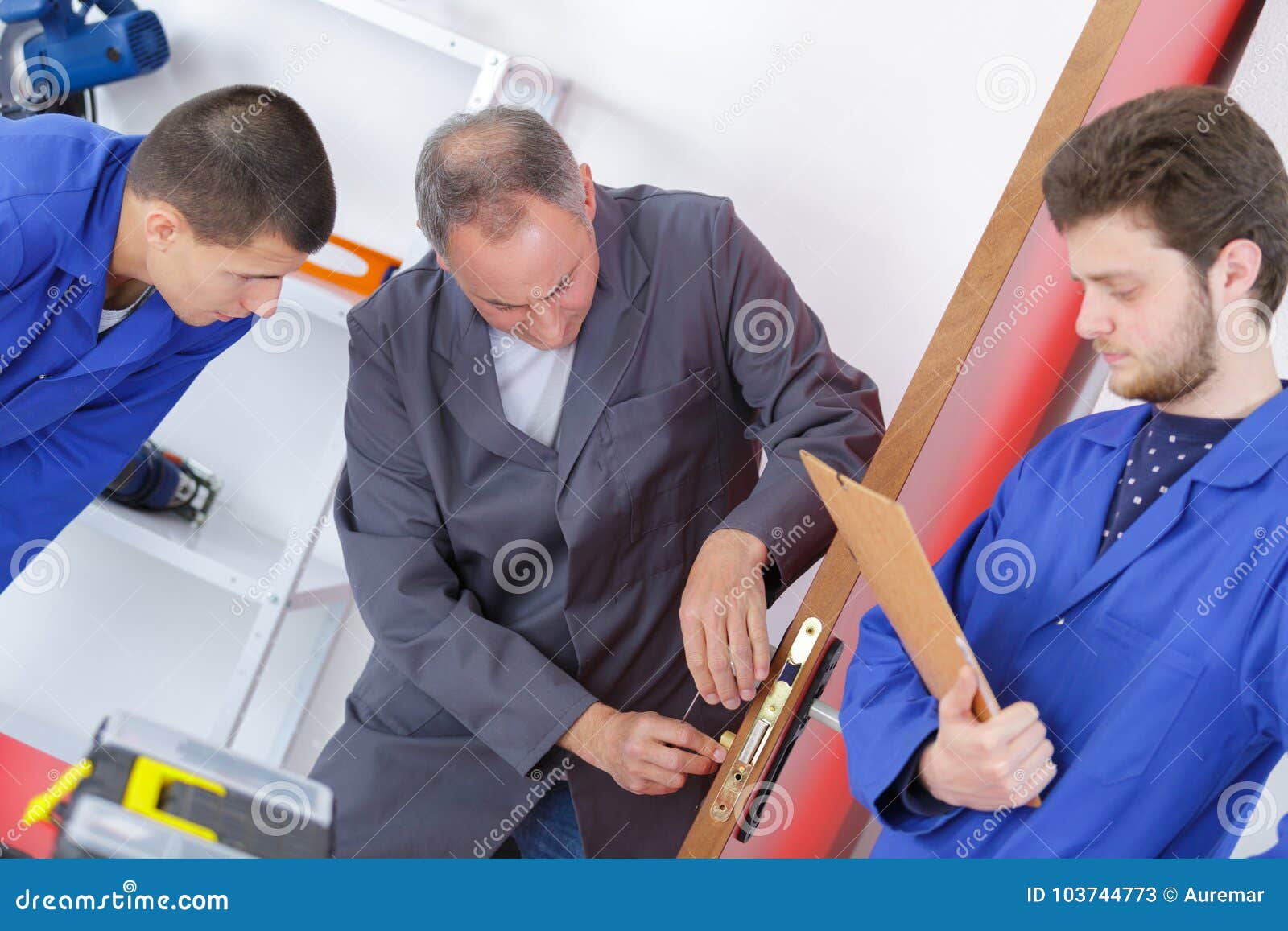 Carpenter Showing Apprentices How To Fix Broken Door Lock