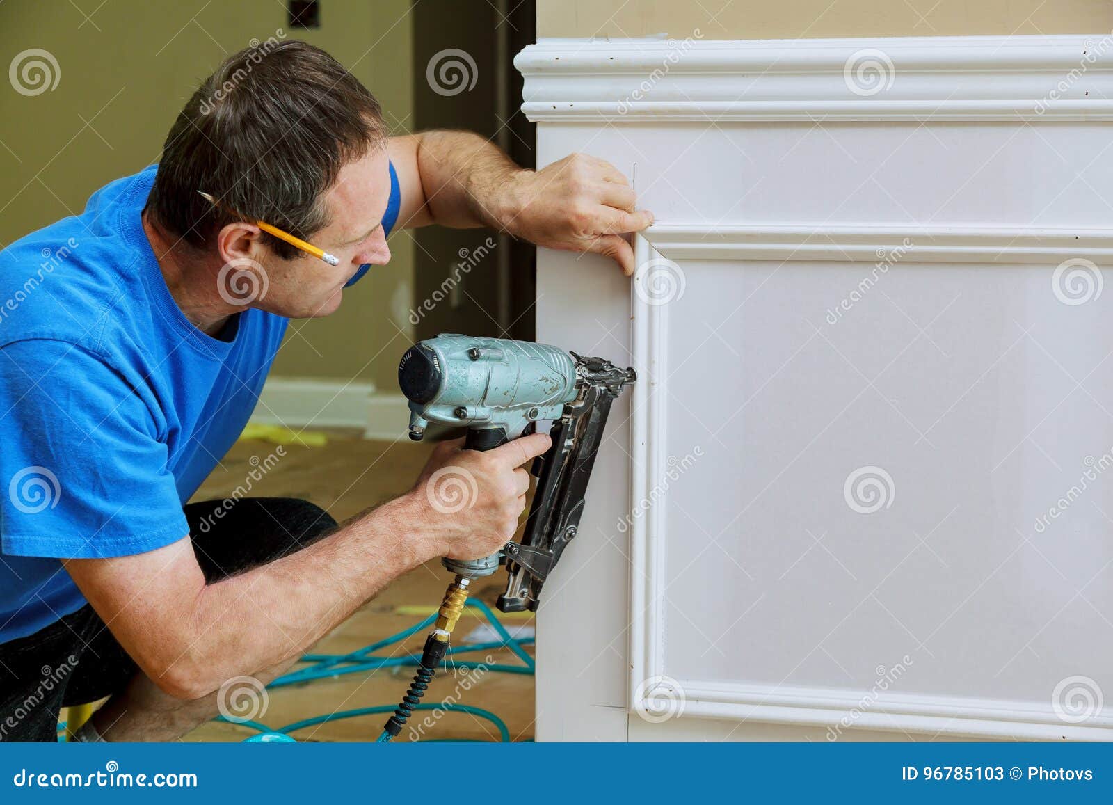 carpenter using a brad nail gun to complete framing trim