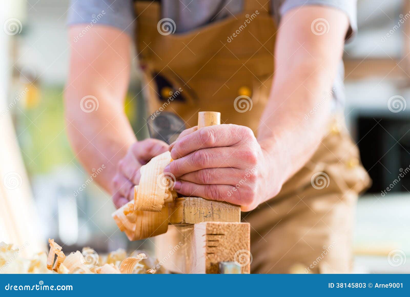 carpenter with wood planer and workpiece in carpentry