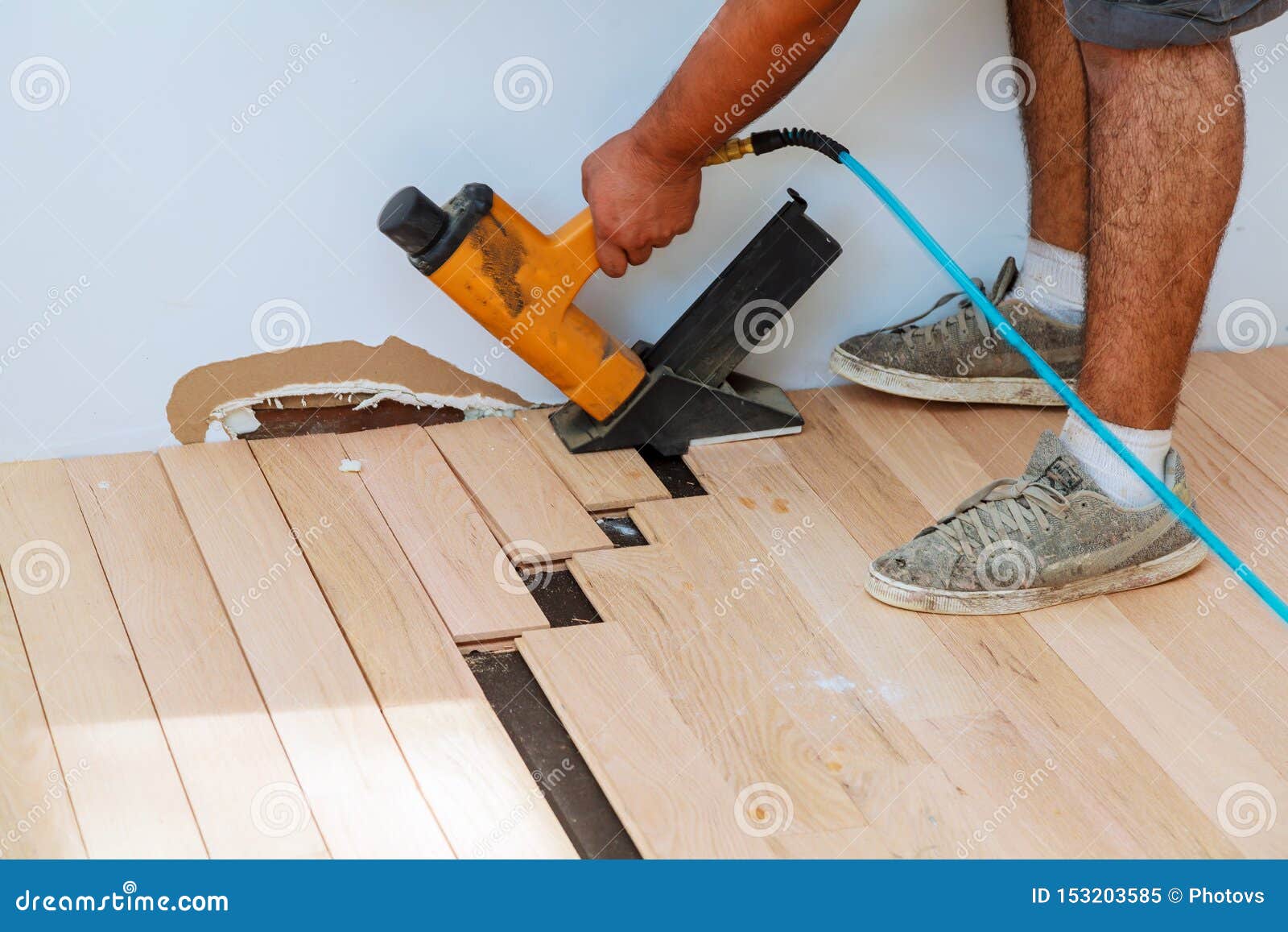 Carpenter Worker Installing Wood Parquet Board With Hammer Stock