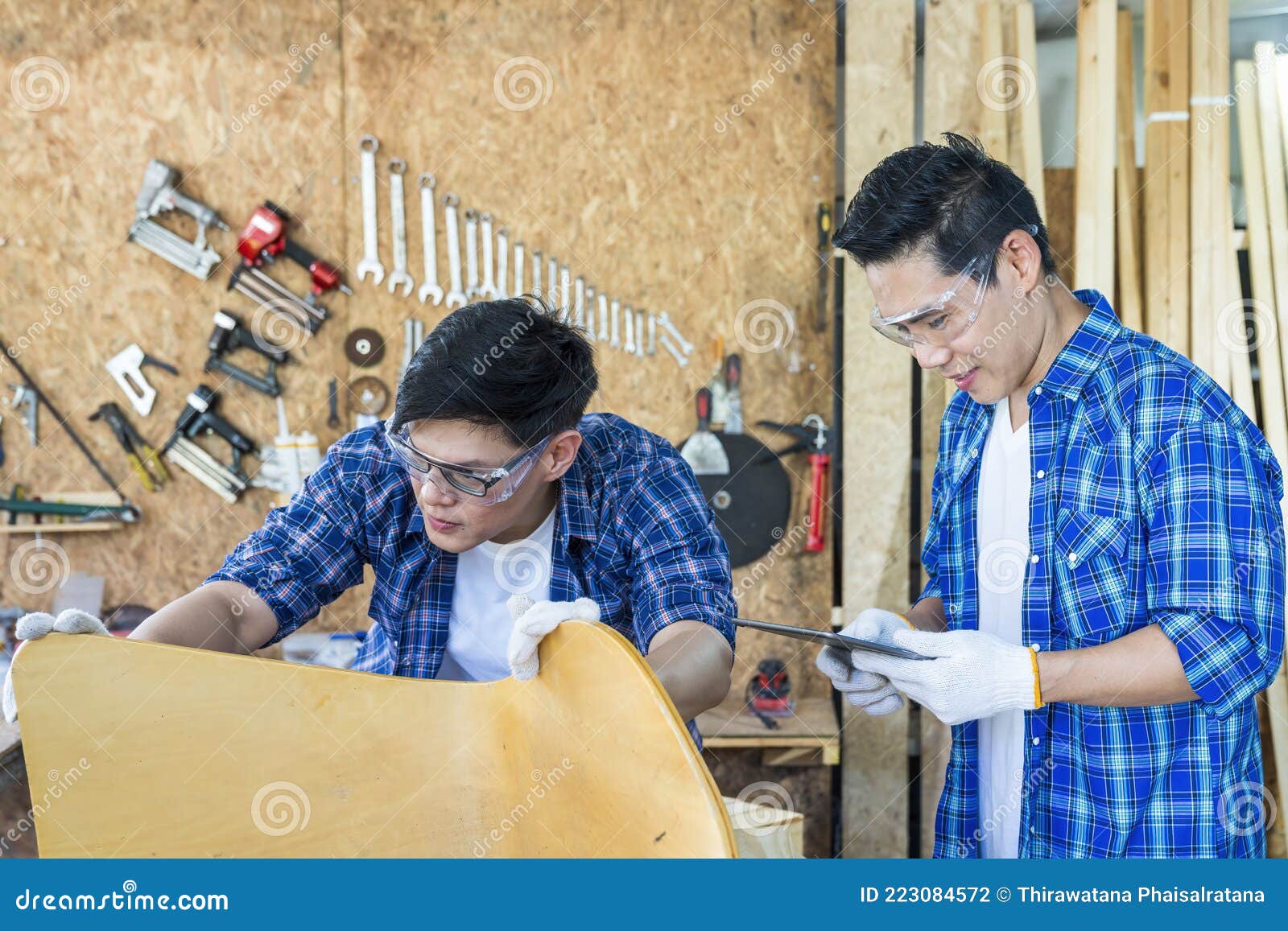 Carpenter Working with Wood in His Carpenter with Tablet in