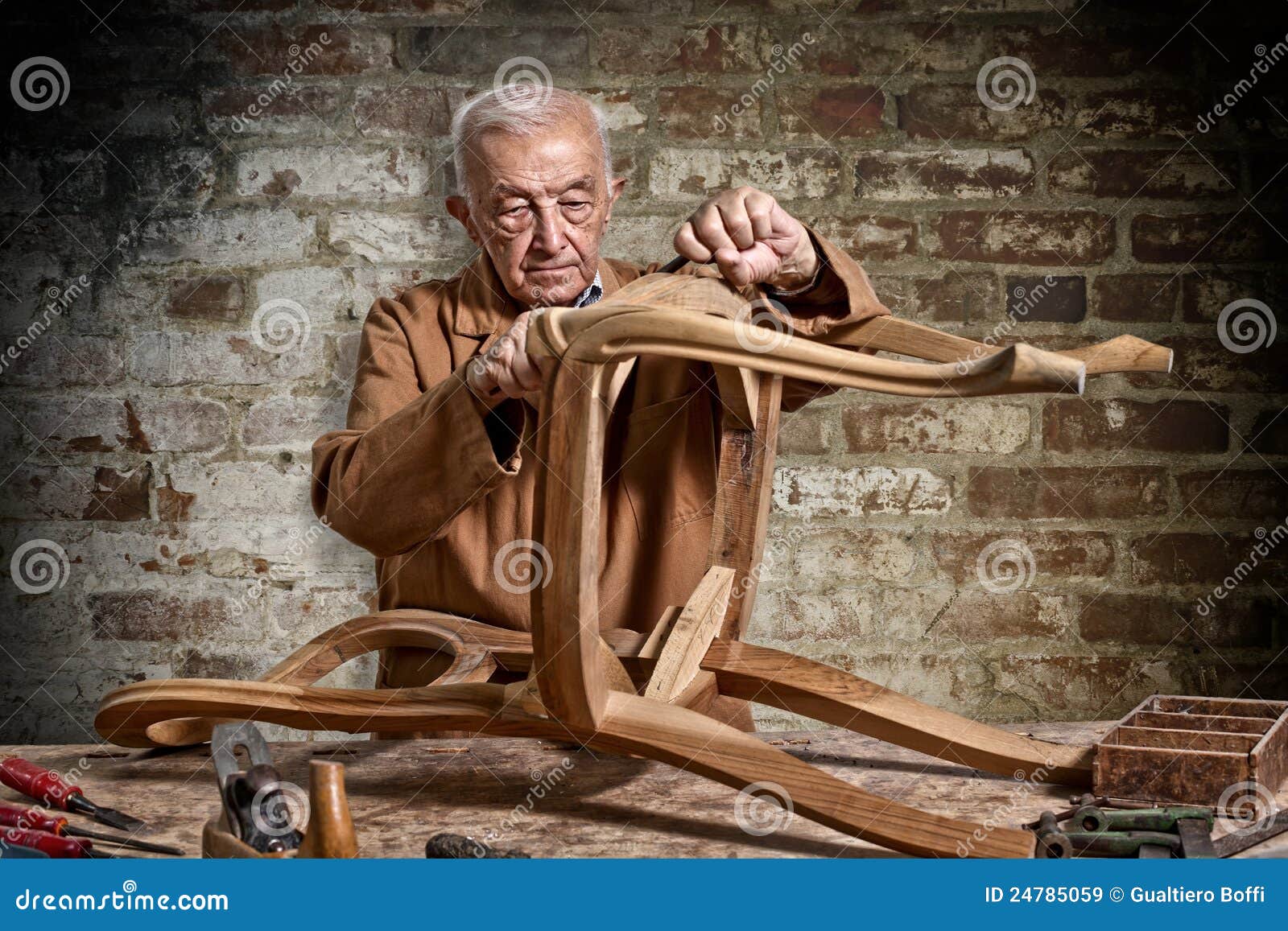 Carpentiere in servizio. Carpentiere anziano alla priorità bassa del mattone del lavoro