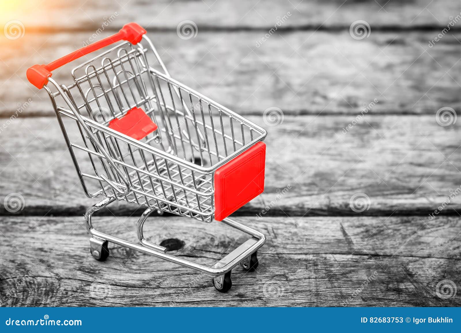 cart from the grocery store on the old wooden background. empty shopping trolley. business ideas and retail trade.