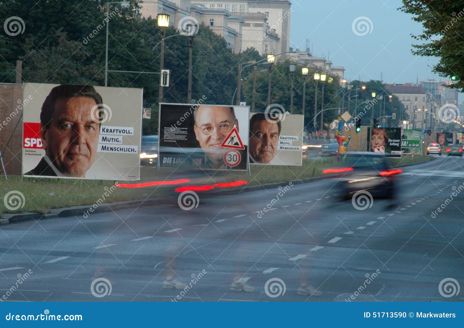 Cartaz da eleição. CERCA DO AGOSTO DE 2005 - BERLIM: trafique em Karl Marx Allee com os cartazes da eleição durante o campagin para as eleições gerais alemãs de 2005, Berlim-Friedrichshain