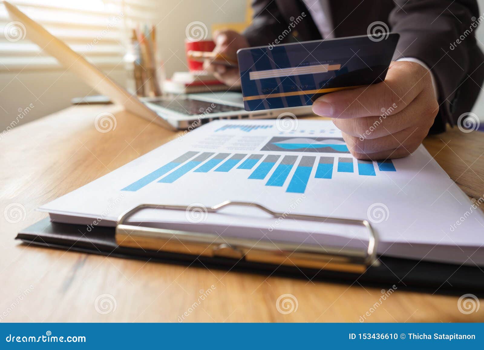 Carte de crédit d'utilisation d'homme d'affaires à l'achat en ligne dans le magasin de site Web d'Internet avec l'ordinateur portable d'ordinateur et le téléphone intelligent sur la table de travail dans le bureau