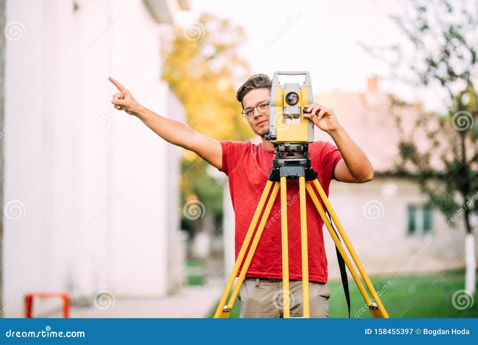 cartographer engineer, surveyor working with total station construction site elevation