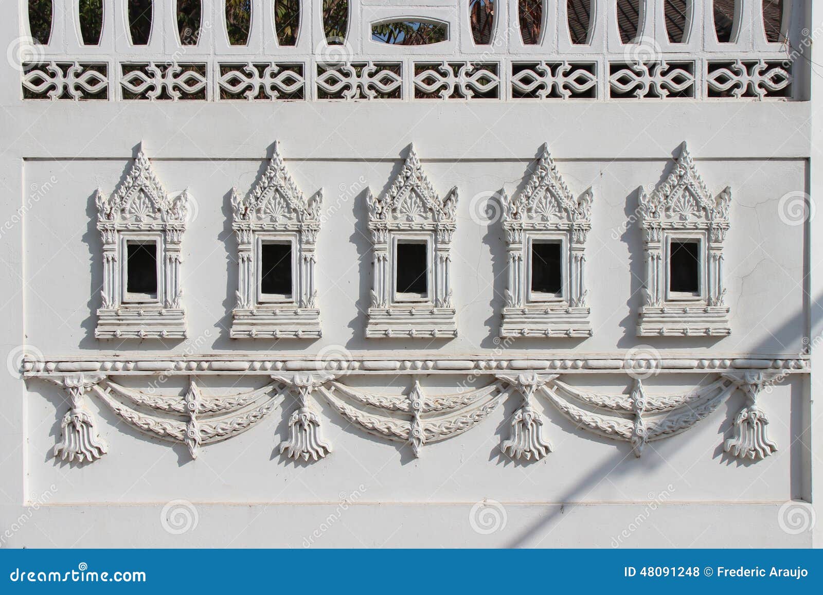 carved patterns decorate the wall of a building (thailand)