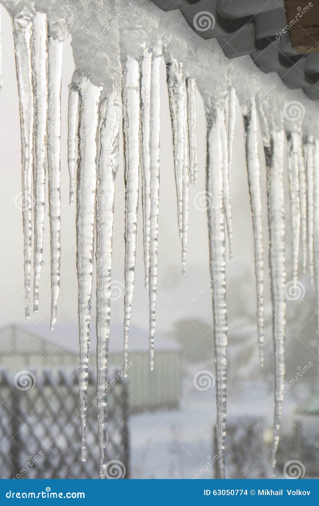 Carámbanos que cuelgan de los aleros de la casa, invierno temprano Siberia occidental