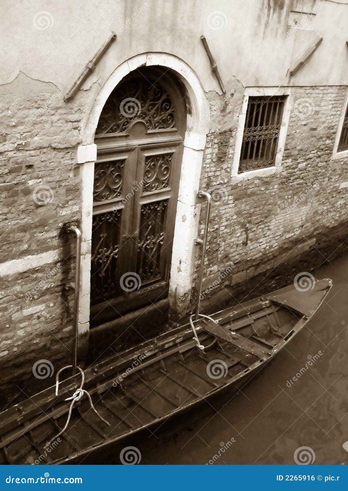 Casa de campo e gôndola de Veneza. Gôndola Venetian na frente da porta de uma casa de campo Venetian velha, Italy, fotografia em cores do sepia