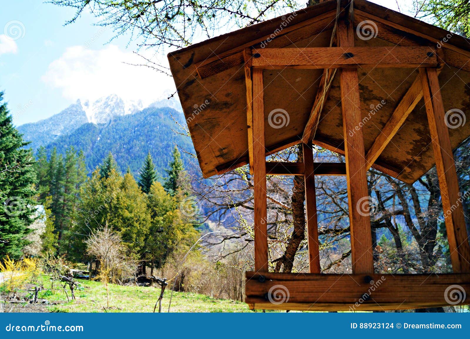 Casa para los pájaros en un fondo de montañas nevosas