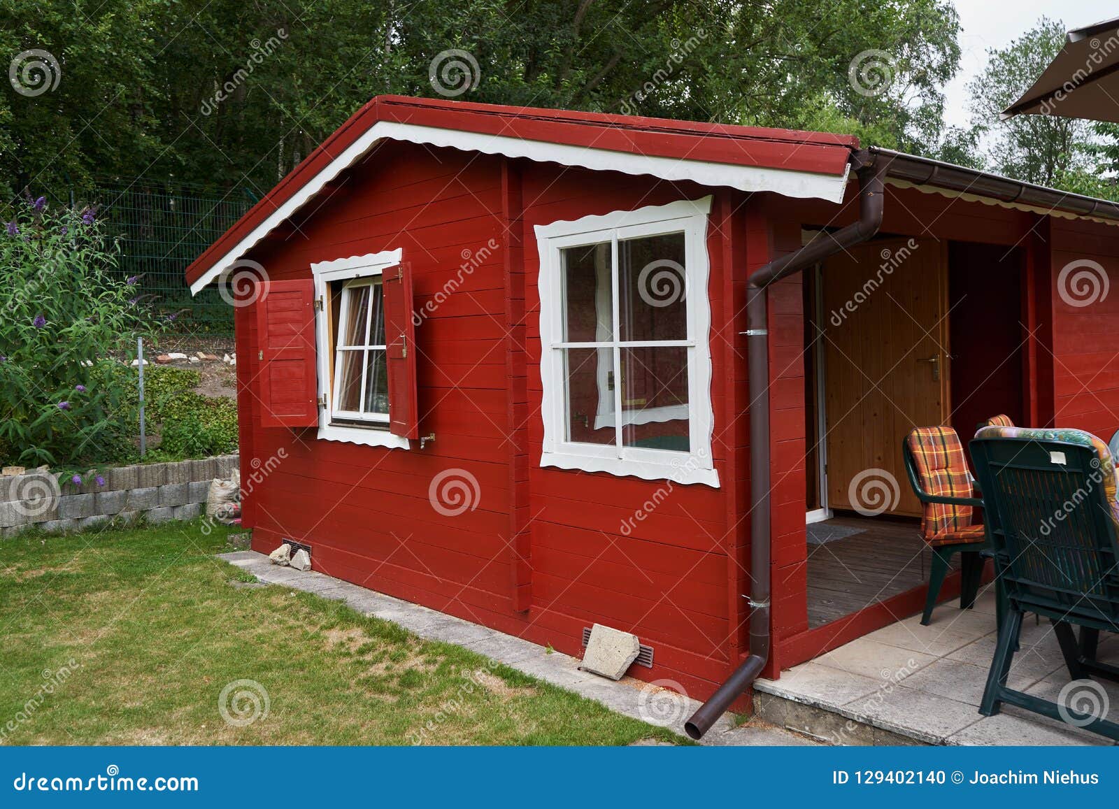 Casa Pintada Pequeño Rojo Del Jardín Con El Patio Foto de archivo - Imagen  de primavera, vacaciones: 129402140