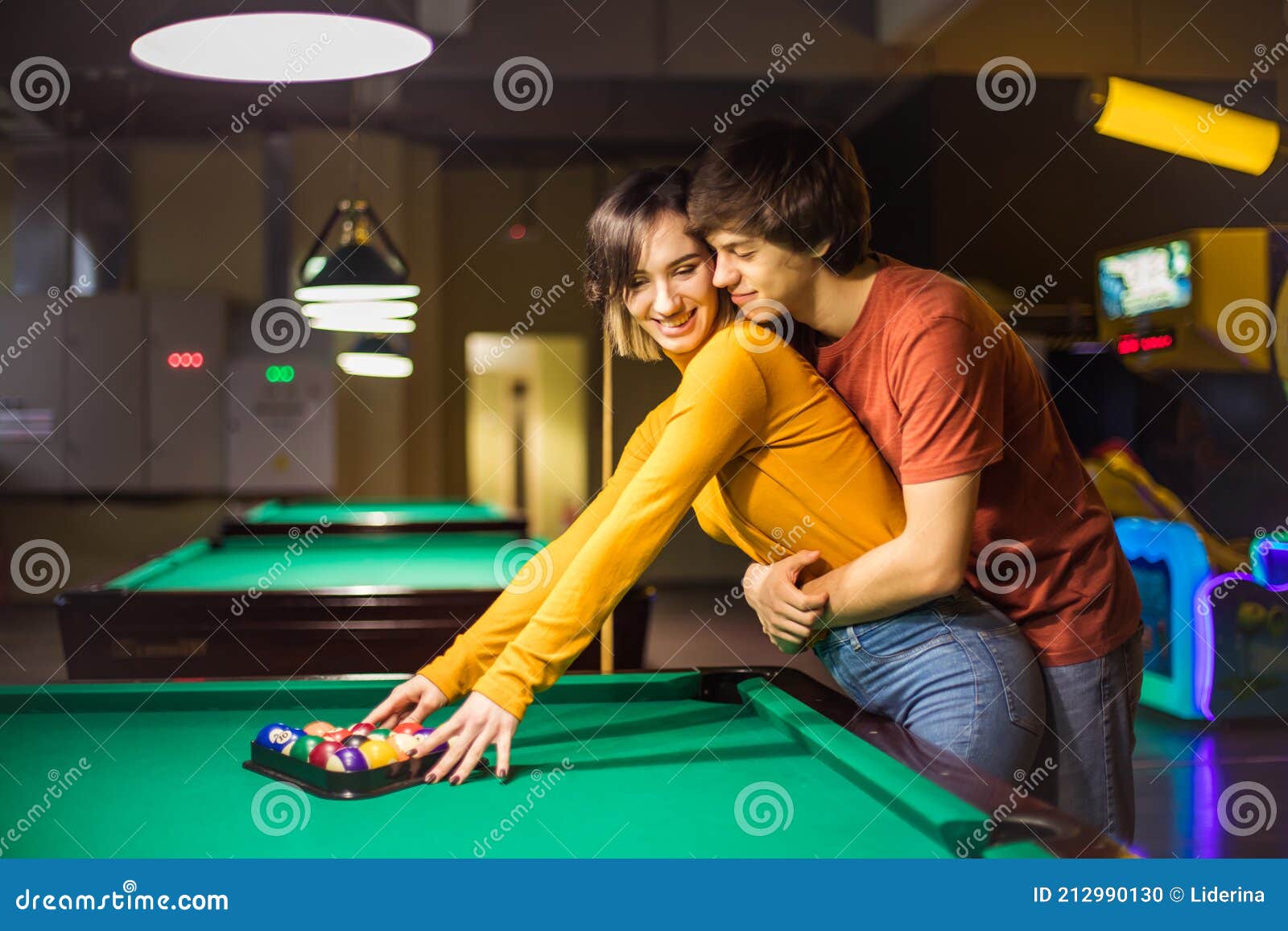 Namorado carinhoso aprendendo sua namorada a jogar sinuca