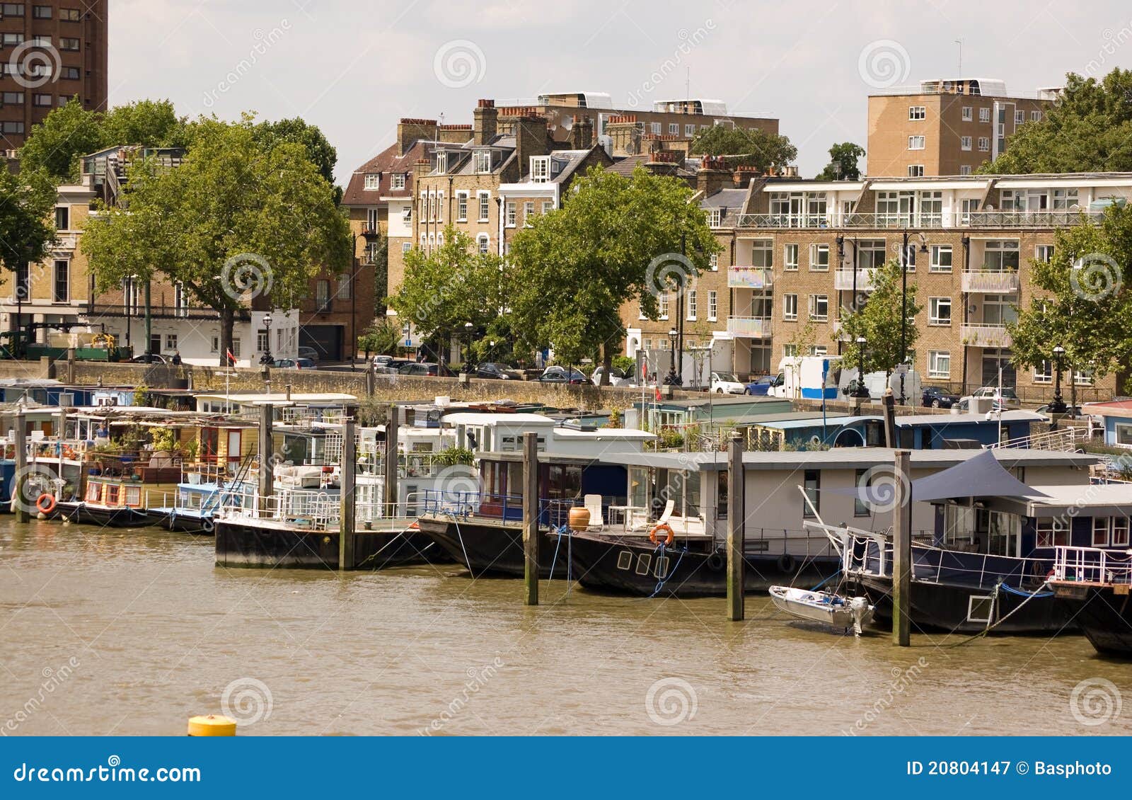 Casas flutuantes, alcance de Chelsea. Uma fileira das casas flutuantes amarradas nos bancos do rio Tamisa no alcance de Chelsea, Londres.