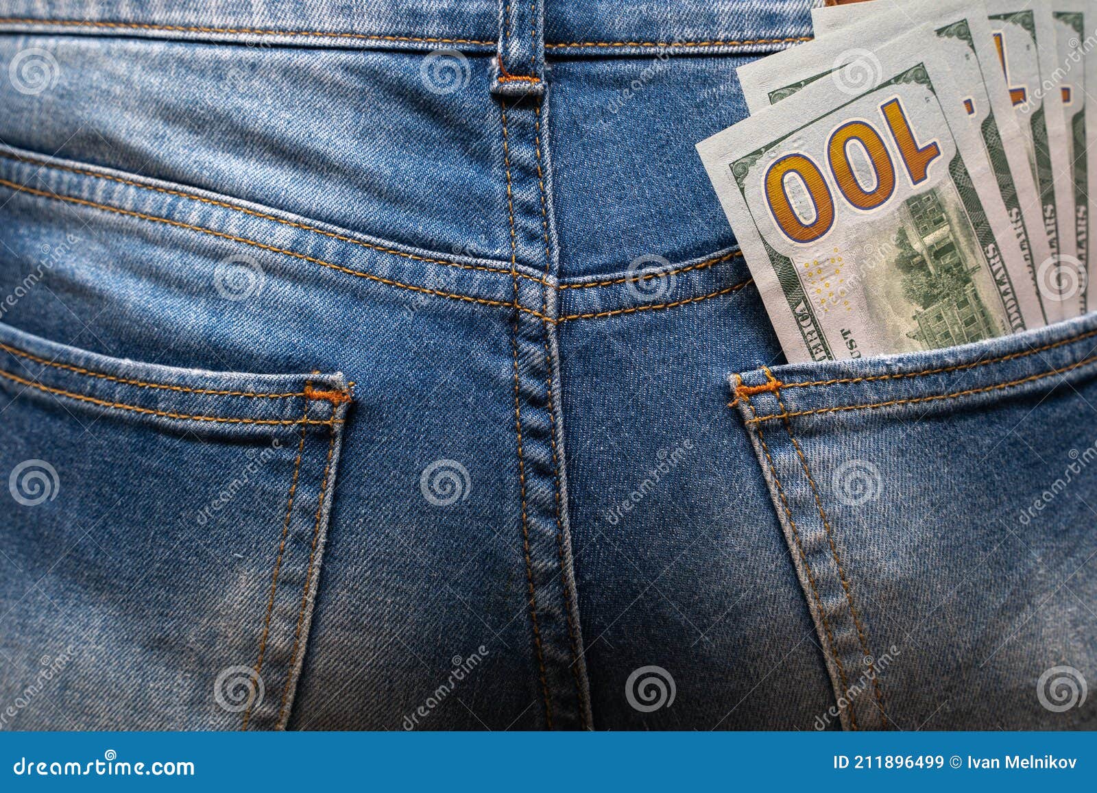 cash in your pocket. a hundred dollar bills stuck out of the back pocket of blue jeans. money saving concept