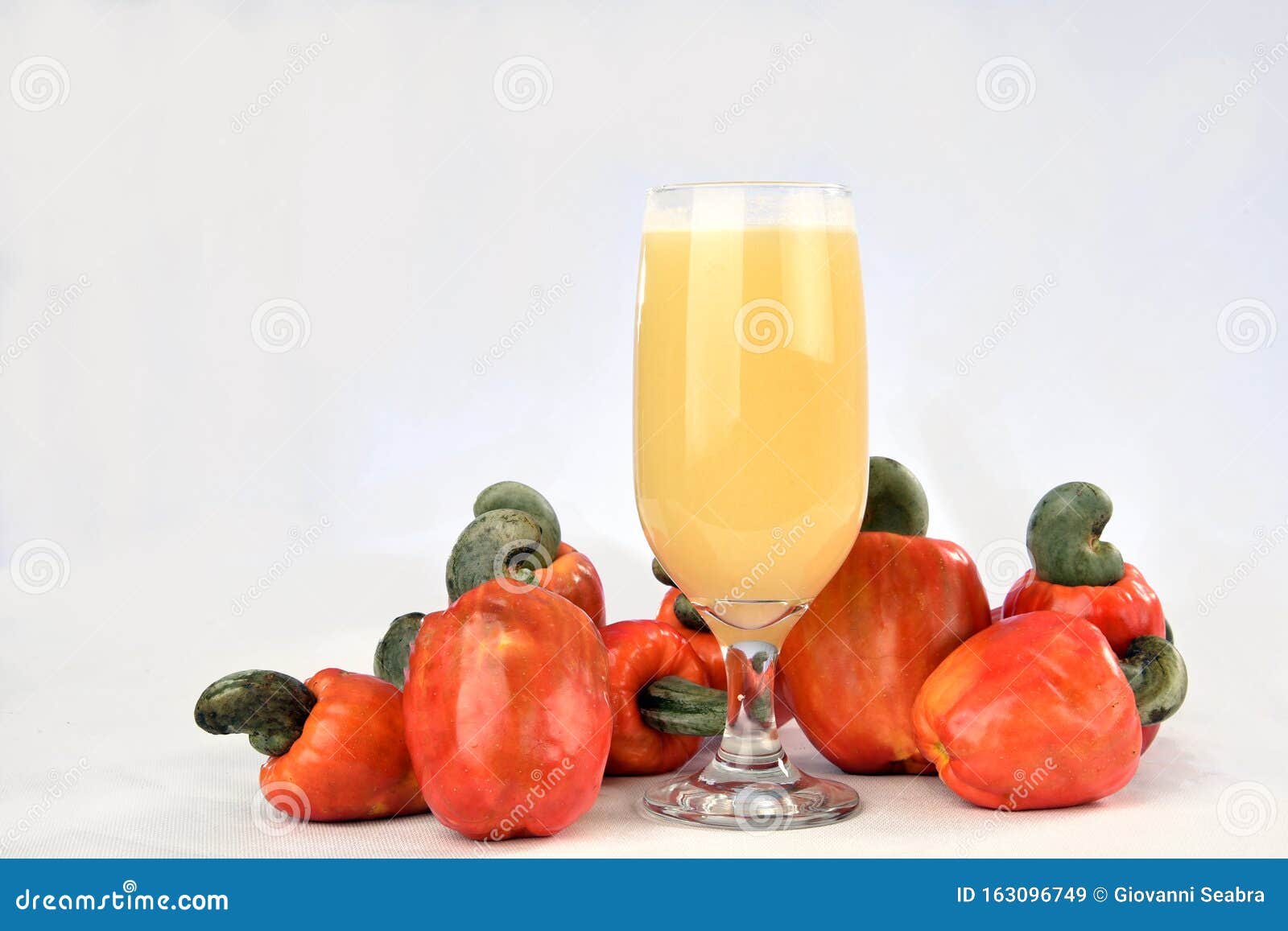 Cashew Nuts Isolated with Glass of Fruit Juice on White Background