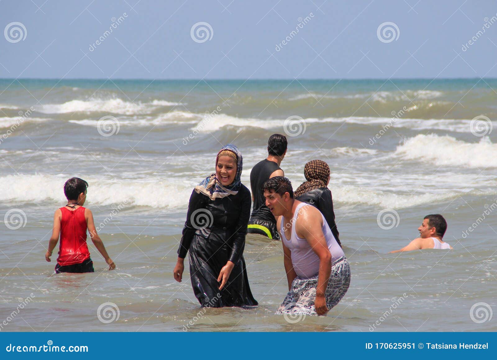 Caspian Sea, Iran - May 25, 2017: People Have Fun and Swim Dressed in