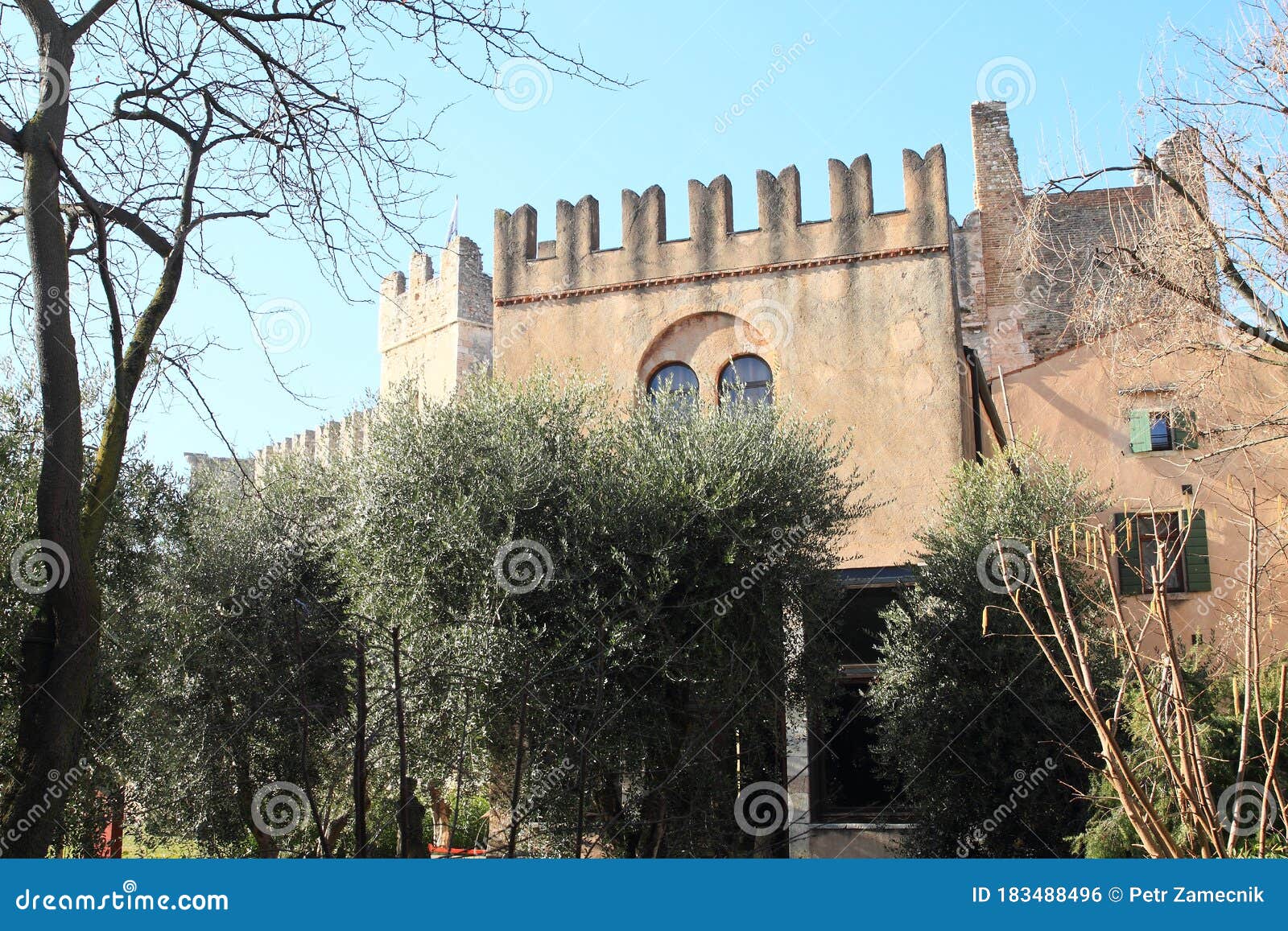 castle castello scaligero behind trees and bushes
