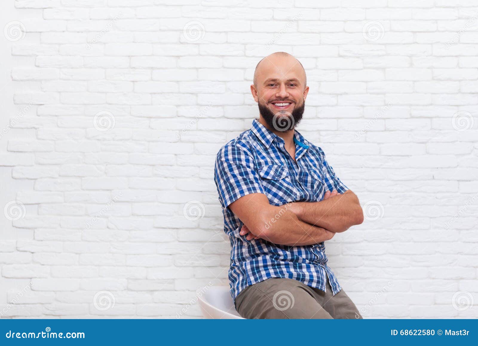 casual bearded business man sitting smiling folded hands office