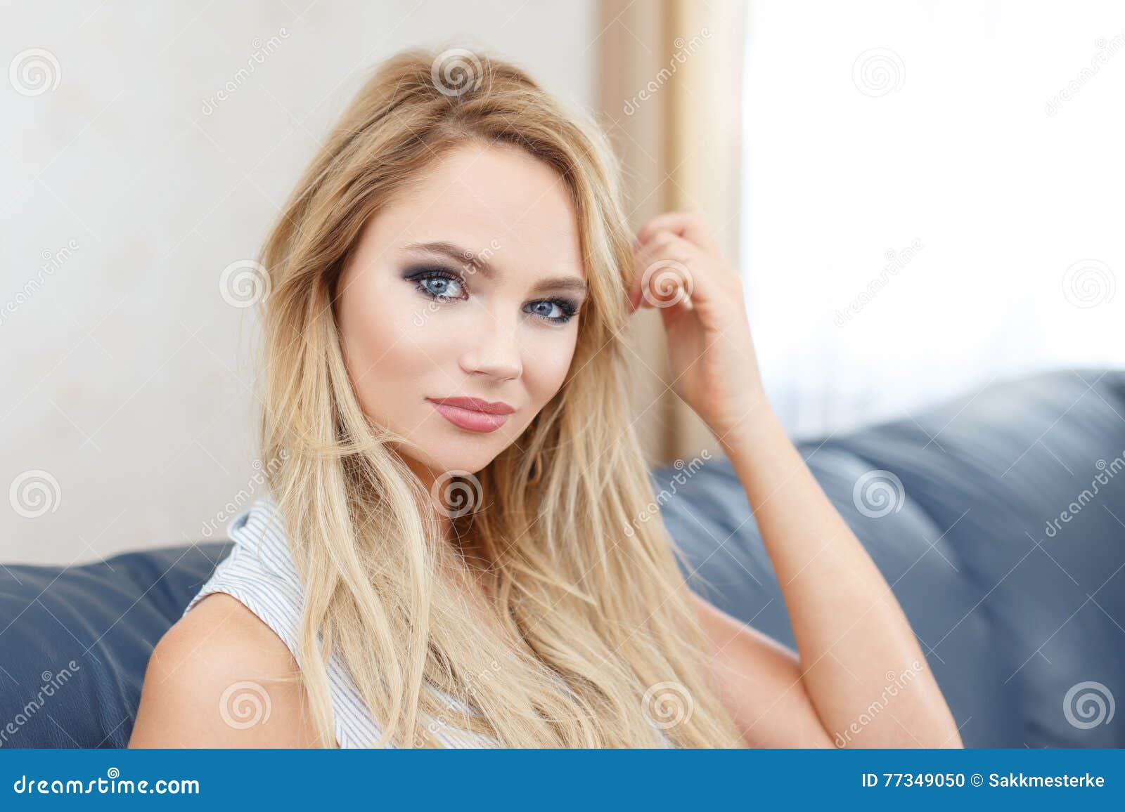 casual blonde woman sit on sofa in living room