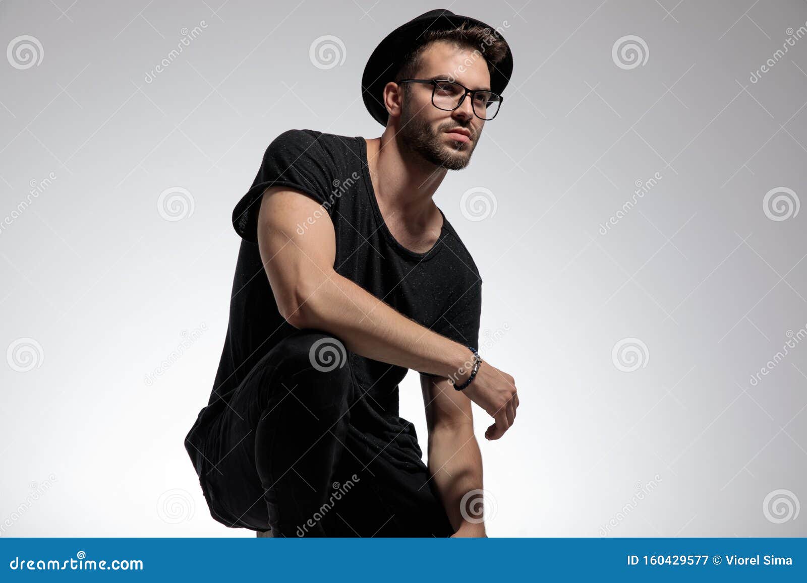 casual man standing crouched and looking away pensive