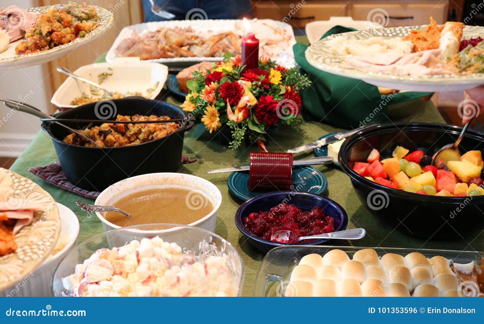 casual thanksgiving feast on table with plates being filled