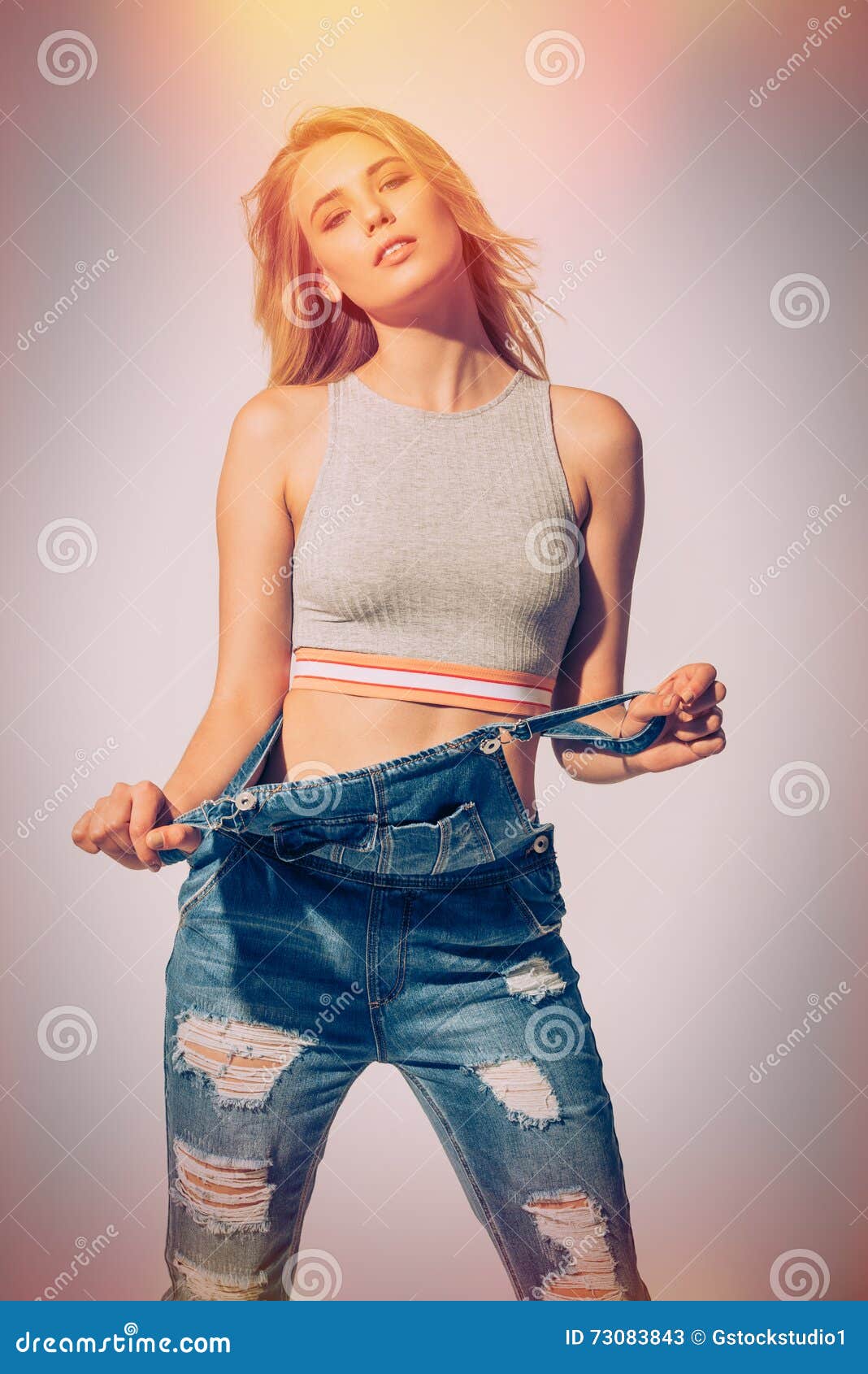 young woman wearing jeans and bra taking off her clothes, Stock Photo,  Picture And Royalty Free Image. Pic. WR3257458