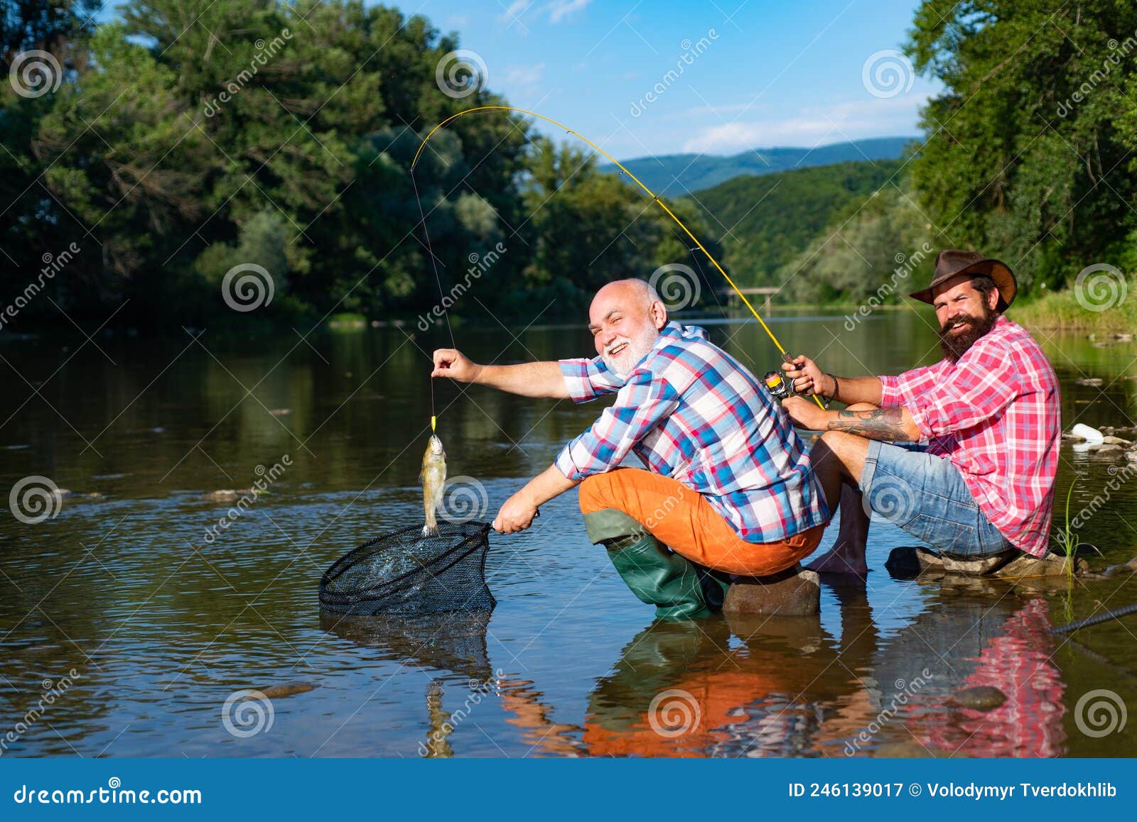 Catching Fish. Two Men Friends Fisherman Fishing on River Stock