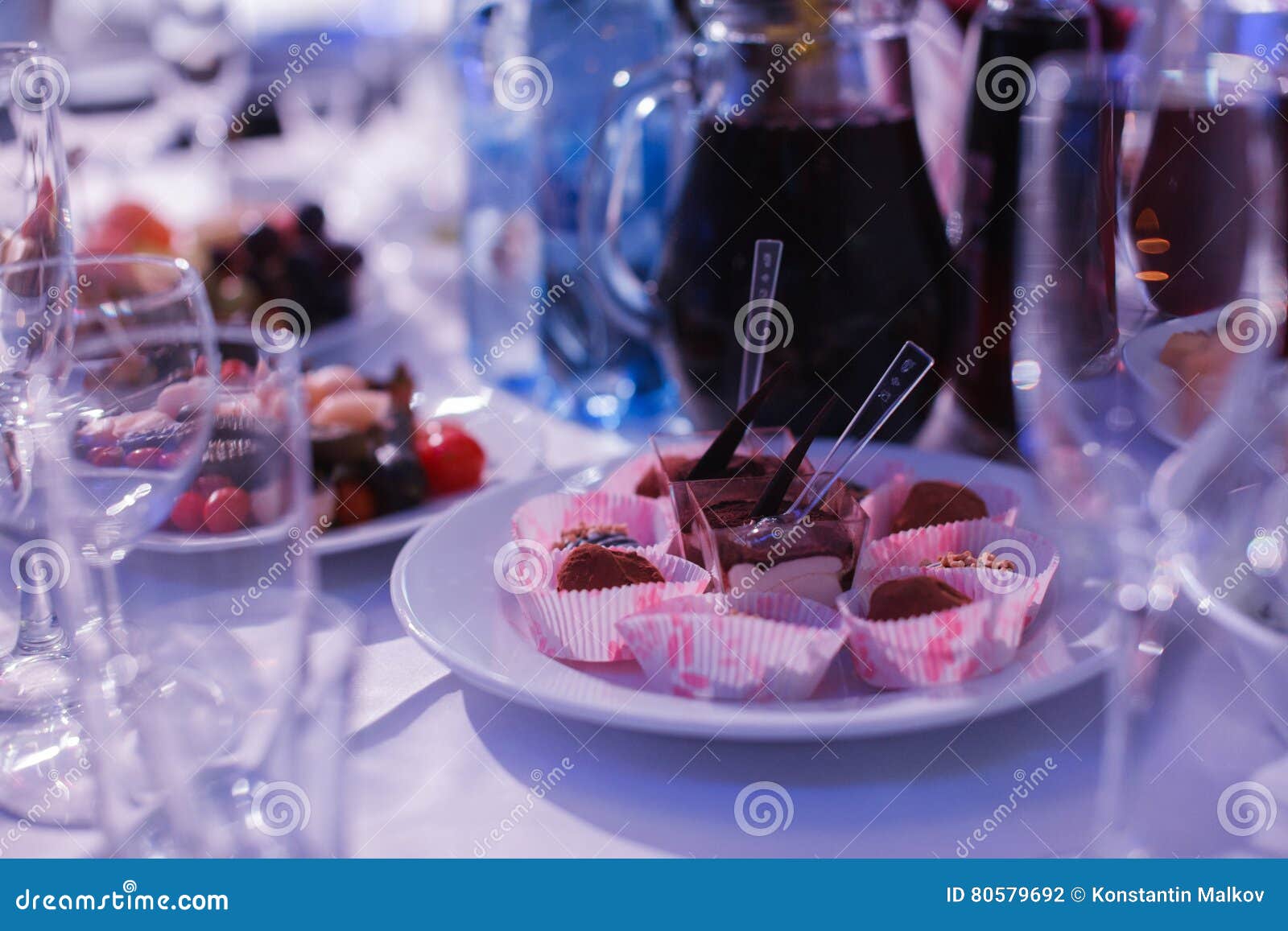 catering banquet table with baked food snacks, sandwiches, cakes, cups and plates, self serve, open buffet dinner