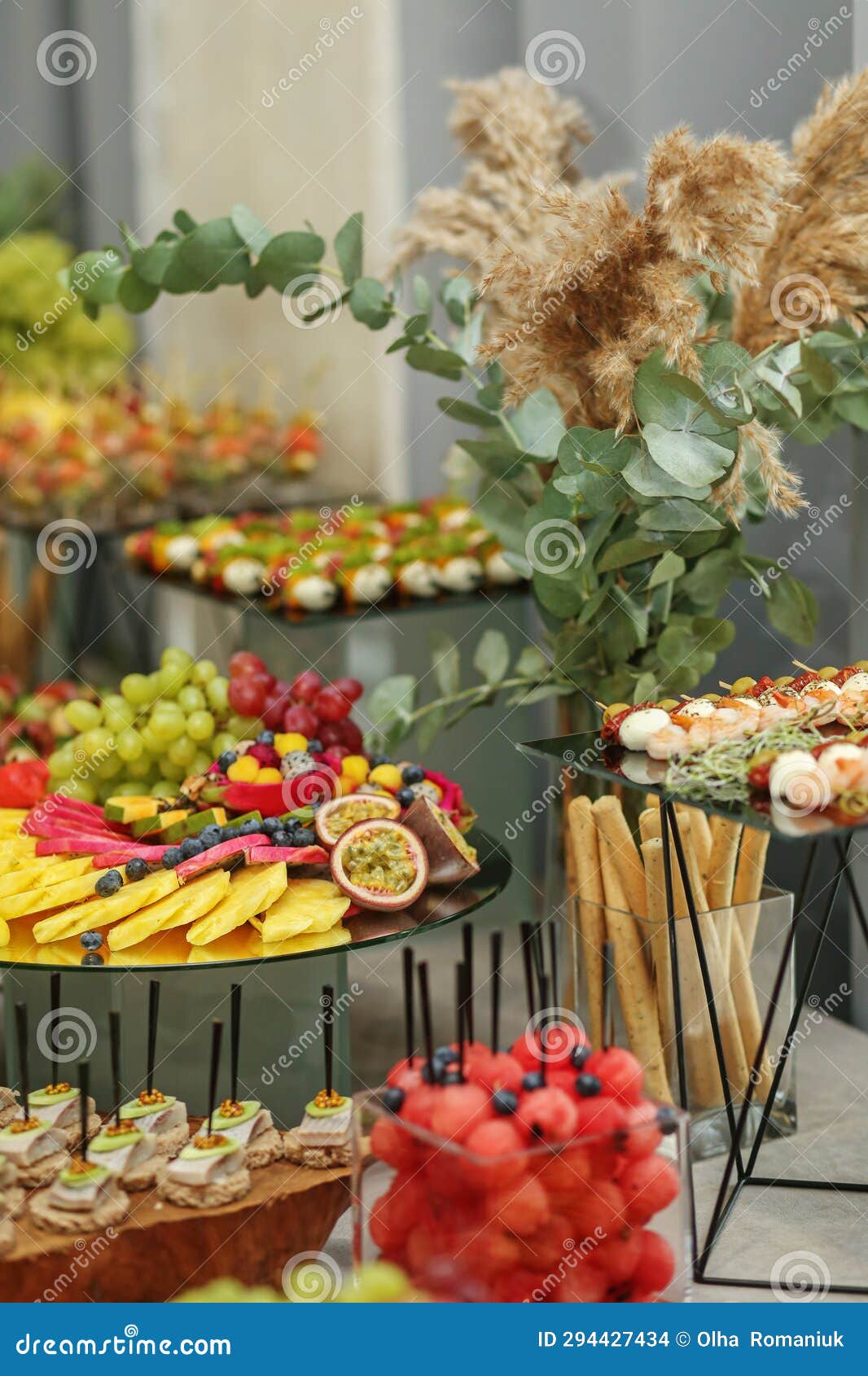 catering buffet table with snacks and appetizers. set of varios fruits and berries. decorative vase