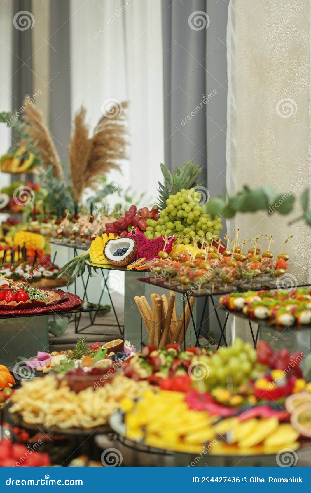 catering buffet table with snacks and appetizers. set of varios fruits and berries. decorative vase