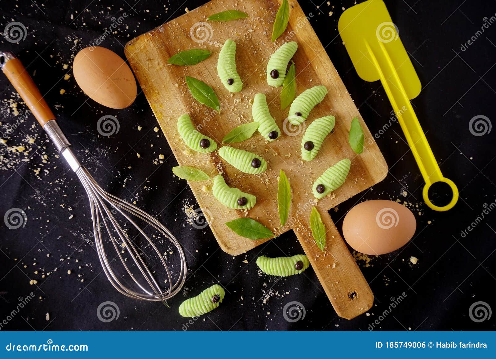 Caterpillar Cake on the Wooden Tray with Eggs and Powder on the Side