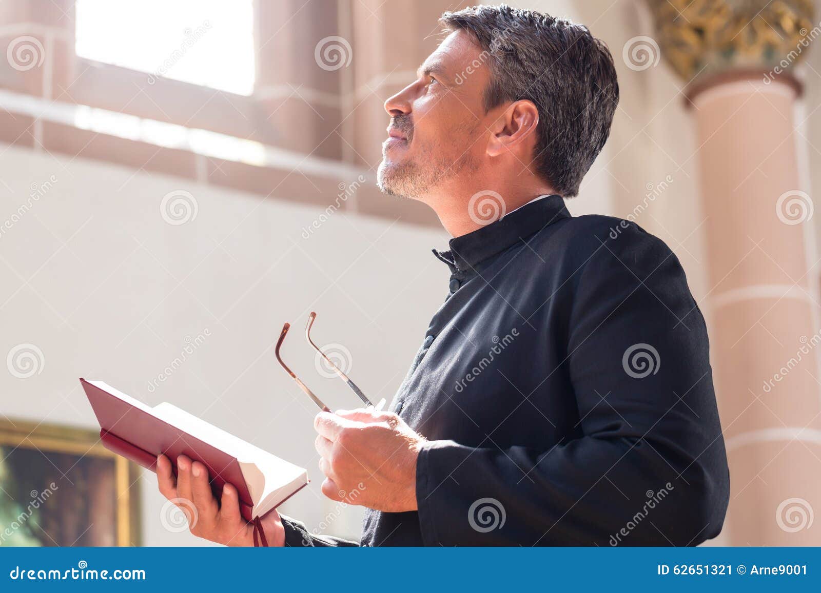 catholic priest reading bible in church